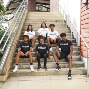 Group of people sitting on the stairs outside a building