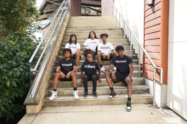 Group of people sitting on the stairs outside a building