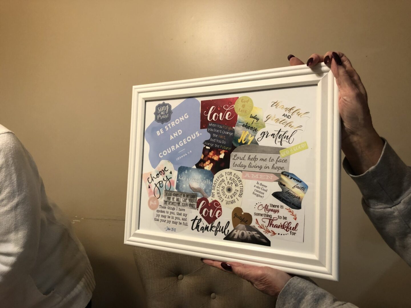 A person holding a frame in hand with some stickers pasted