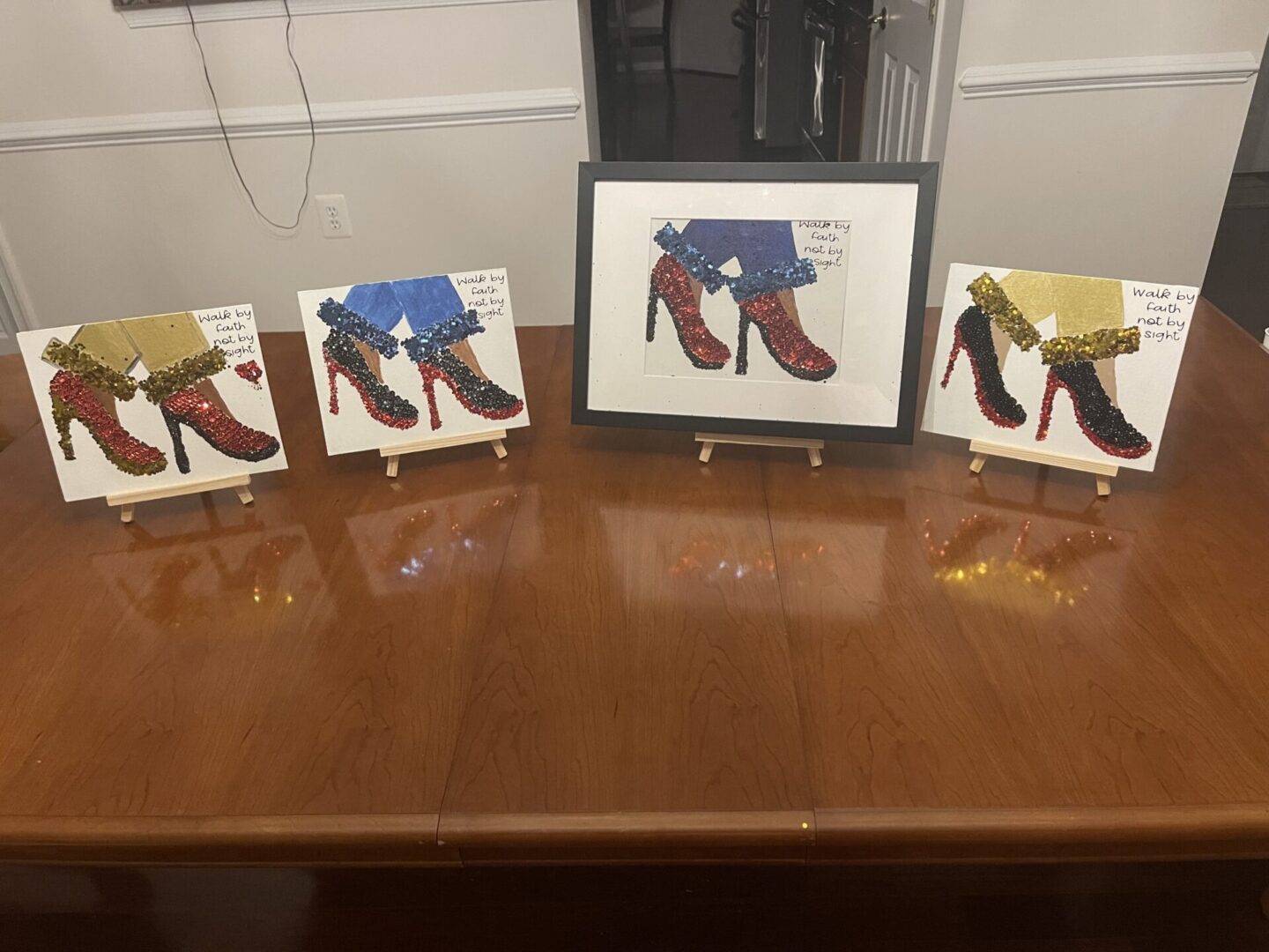 Framed artwork of colorful boots displayed on a wooden table.